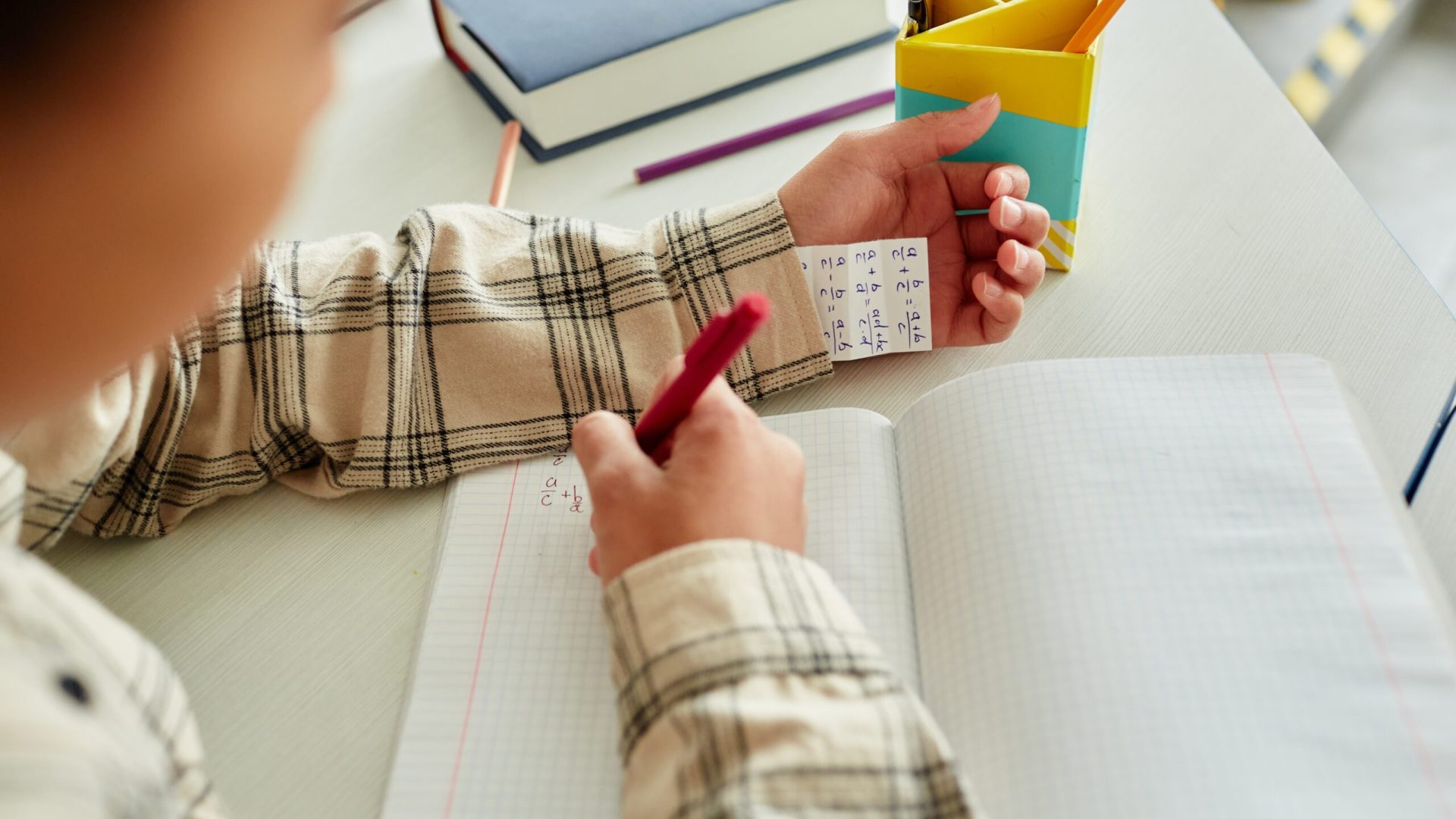 Close,Up,Of,Unrecognizable,Young,Boy,Cheating,During,Test,In