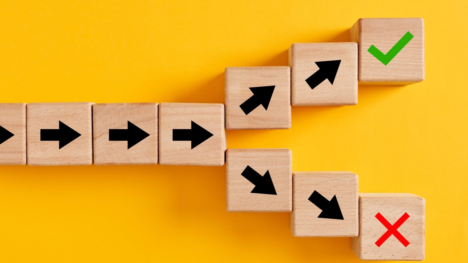 Arrow,Symbols,On,Wooden,Cubes,Splitting,Into,Different,Directions,Towards