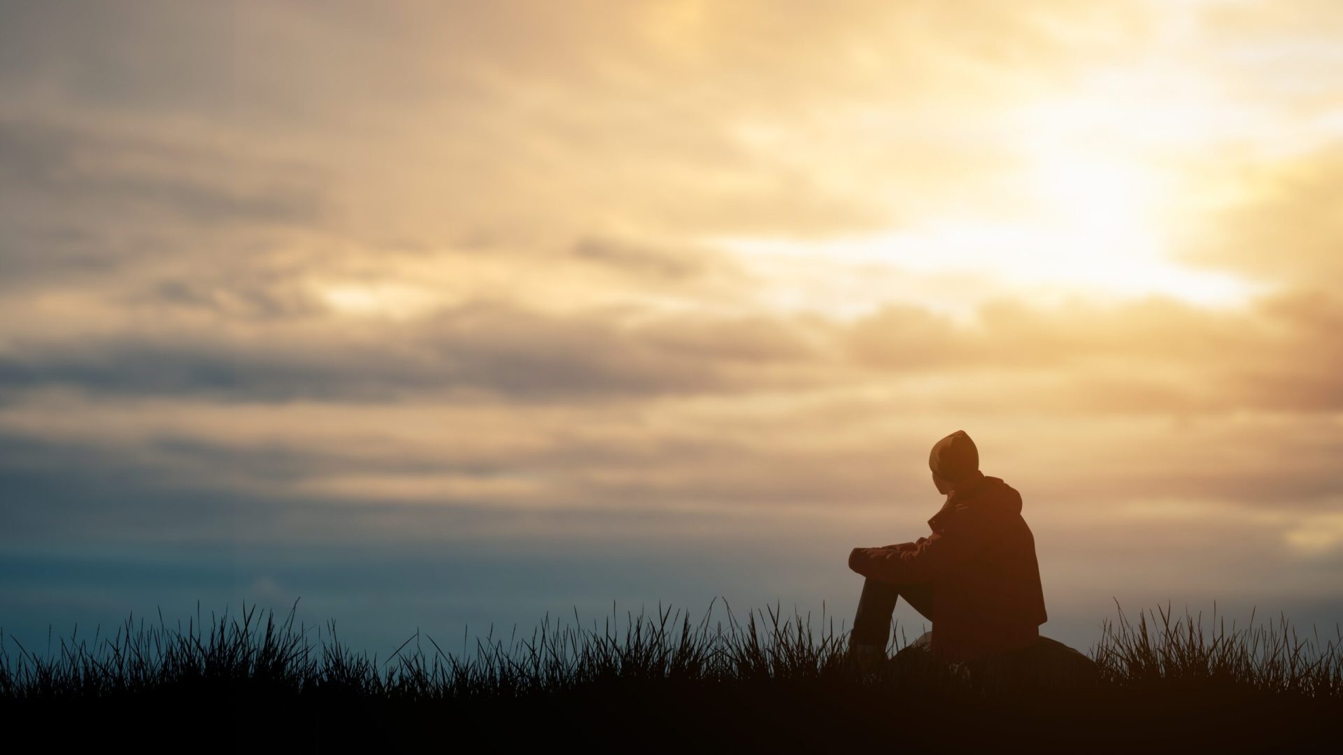 Silhouette,Of,Young,Man,Sits,Praying,Alone,At,The,Top