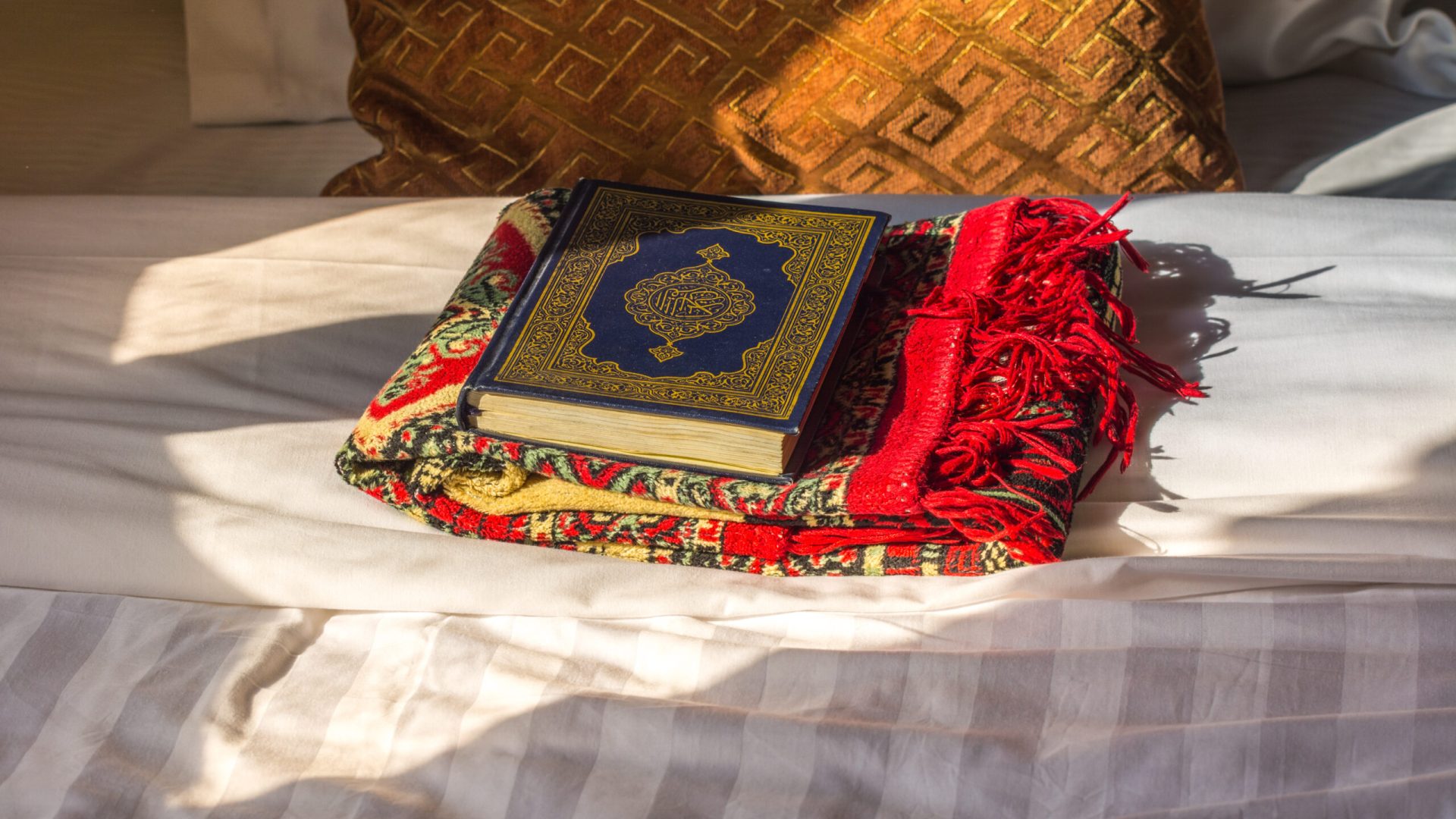Koran,Bible,And,A,Carpet,On,The,Bed,With,Background